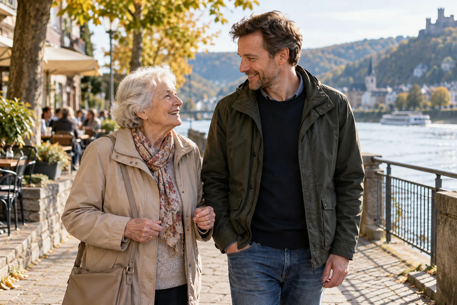 Eine ältere Frau und ein Begleiter im Gespräch an einer Uferpromenade